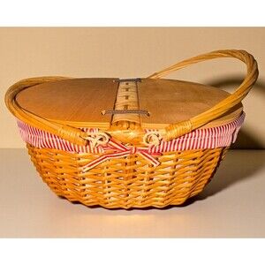 Wicker picnic basket wooden split-lid and a red and white striped fabric liner.